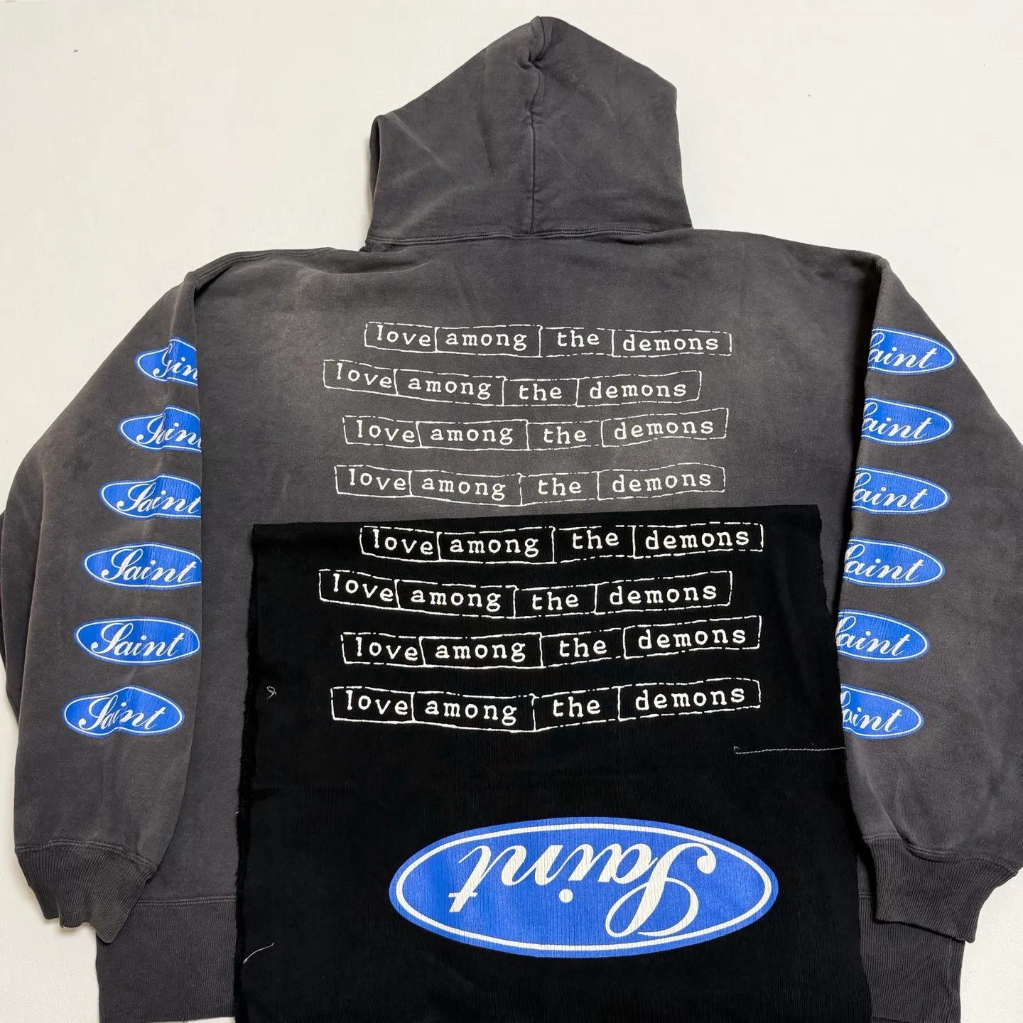 Printed panel SAINT Mxxxxxx HOODIE/LOVE AMONG/BLK blue SAINT barrage slogan hoodie, washed black S-XL, the latest version, revised many times, the version is closer to the original version, and the street flavor is stronger! Heavy washing with water-sprayed fading process for stronger distressing effect. Handmade wormhole destruction treatment. Authentic level extreme distressed crack printing. The main mark and wash mark are all correct versions.